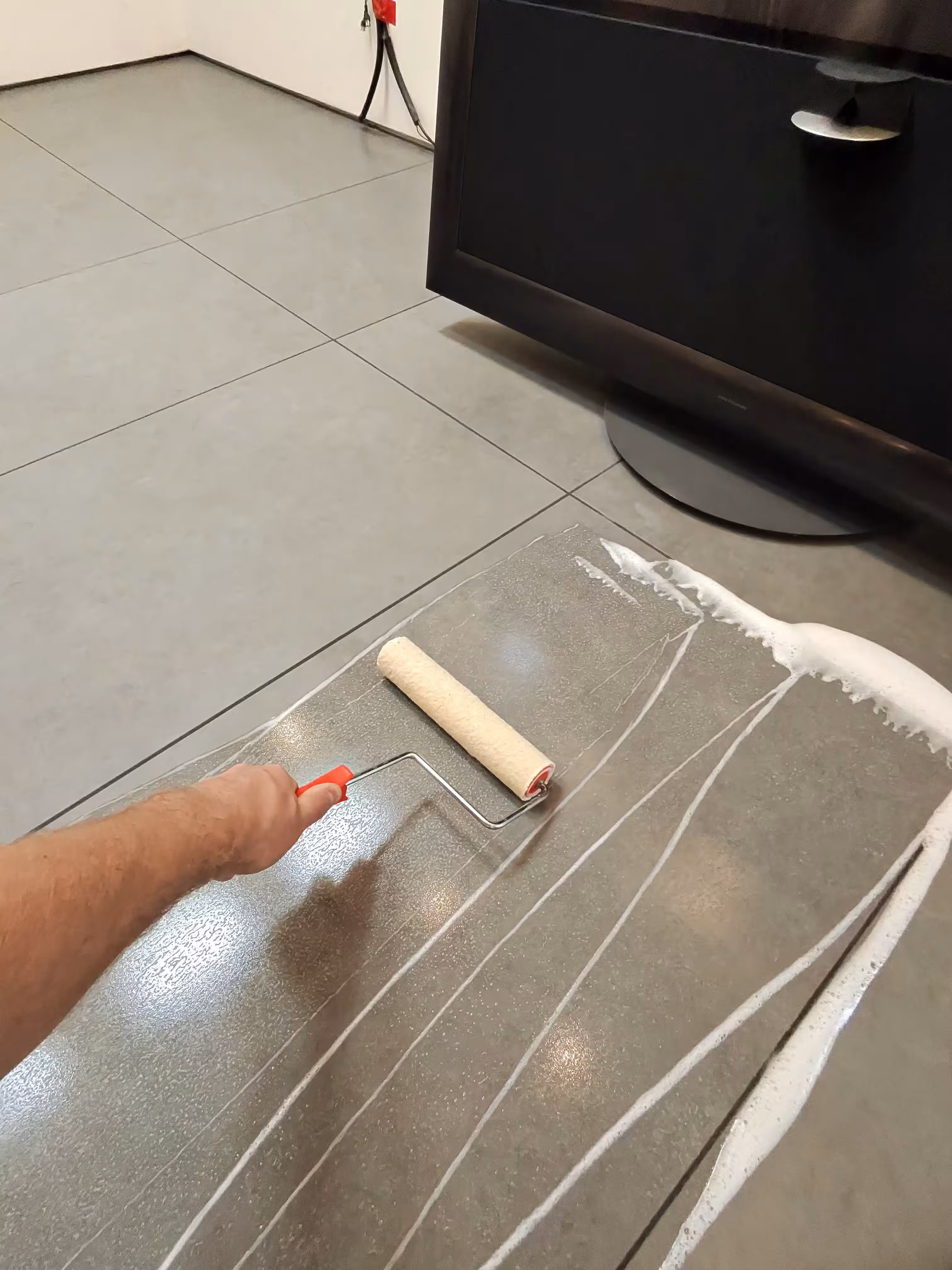 Professional technician applying vinegar solution to remove epoxy haze from porcelain tile